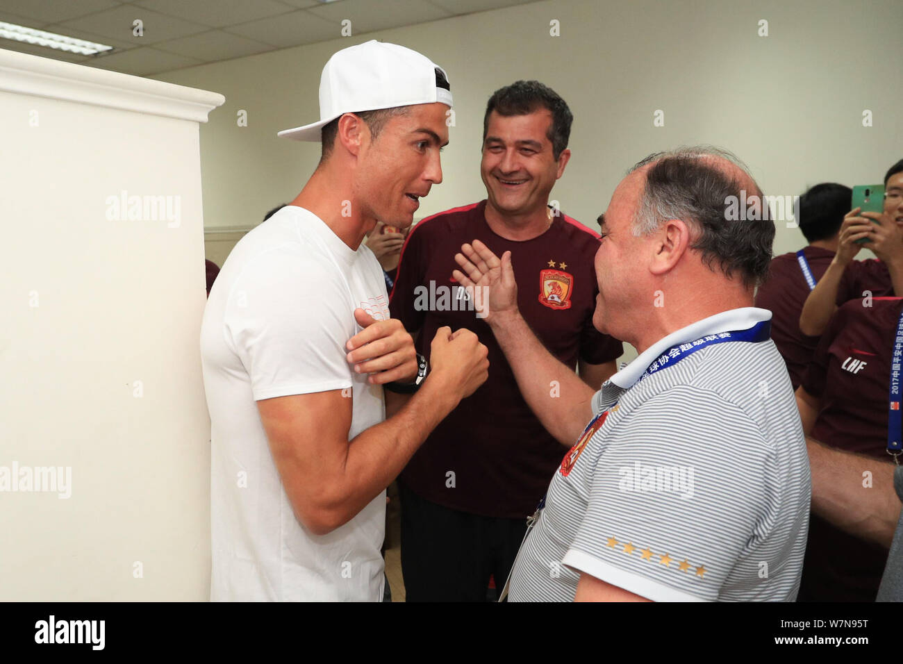Le Portugais Cristiano Ronaldo, joueur de football du Real Madrid, droite, interagit avec un coach de Guangzhou Evergrande C.F. au vestiaire avant le Banque D'Images