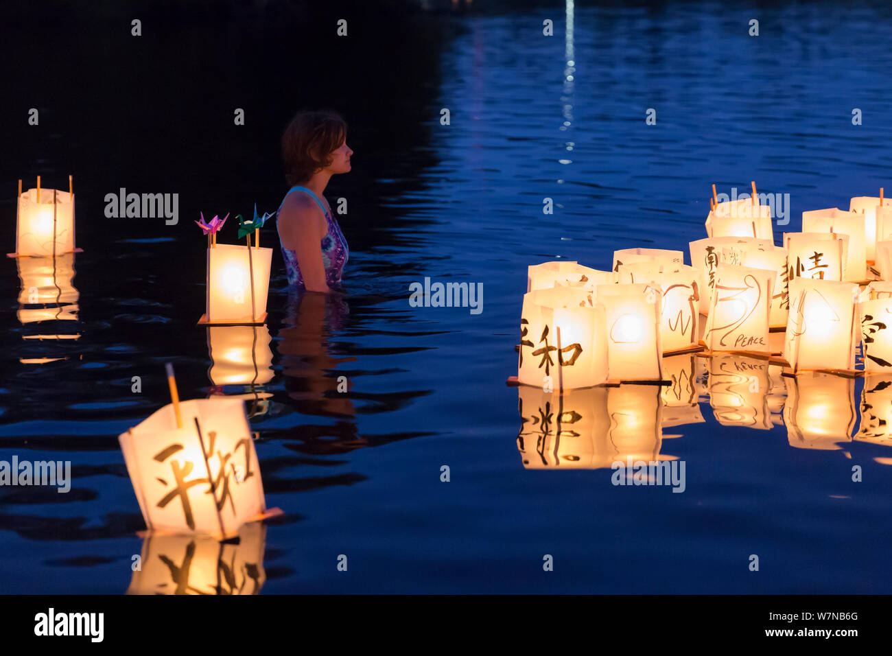 Une jeune femme veille sur des lanternes en papier dans le lac à la Toro Nagashi flottante Lanterne Cérémonie à Seattle, Washington, le 6 août 2019. "D'Hiroshima à l'espoir" est maintenu en mémoire des victimes de la bombe atomique sur l'anniversaire du bombardement de Hiroshima, au Japon. La cérémonie, organisée par un classement de la paix, les libertés civiles, religieuses et organismes du patrimoine culturel, honore les victimes des bombardements d'Hiroshima et Nagasaki, et toutes les victimes de la violence. C'est une adaptation d'un ancien rituel bouddhiste Japonais, le Toro Nagashi, lanternes dans lequel représentant les âmes des morts un Banque D'Images