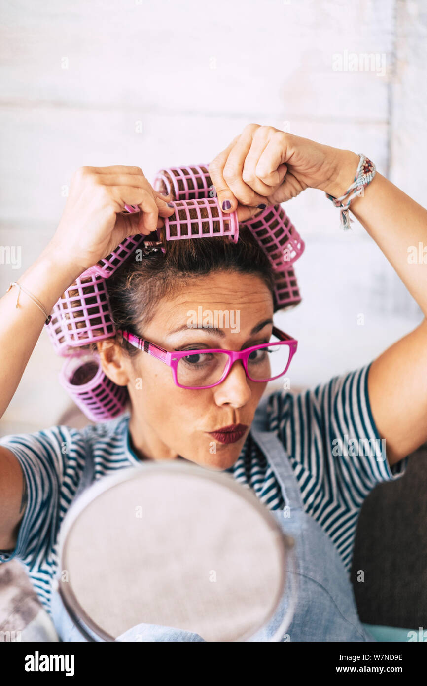 De belles personnes Nice woman at home with bigoudis sur la tête et miroir pour voir ce qui se passe - concept drôle de dame moderne à porter et ha Banque D'Images