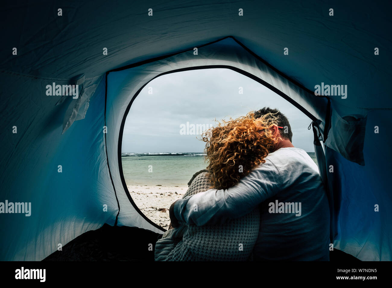 L'amour à l'intérieur d'une tente de camping gratuit à la plage pour un couple vu de dos et méconnaissable - conept du voyage et plein air les gens ensemble pour toujours Banque D'Images
