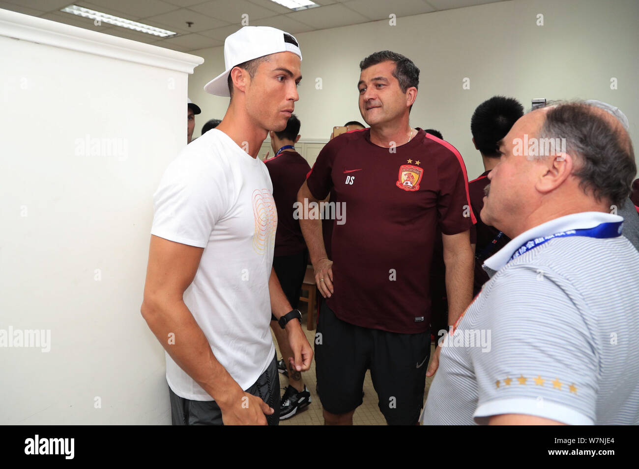 Le Portugais Cristiano Ronaldo, joueur de football du Real Madrid, droite, interagit avec un coach de Guangzhou Evergrande C.F. au vestiaire avant le Banque D'Images
