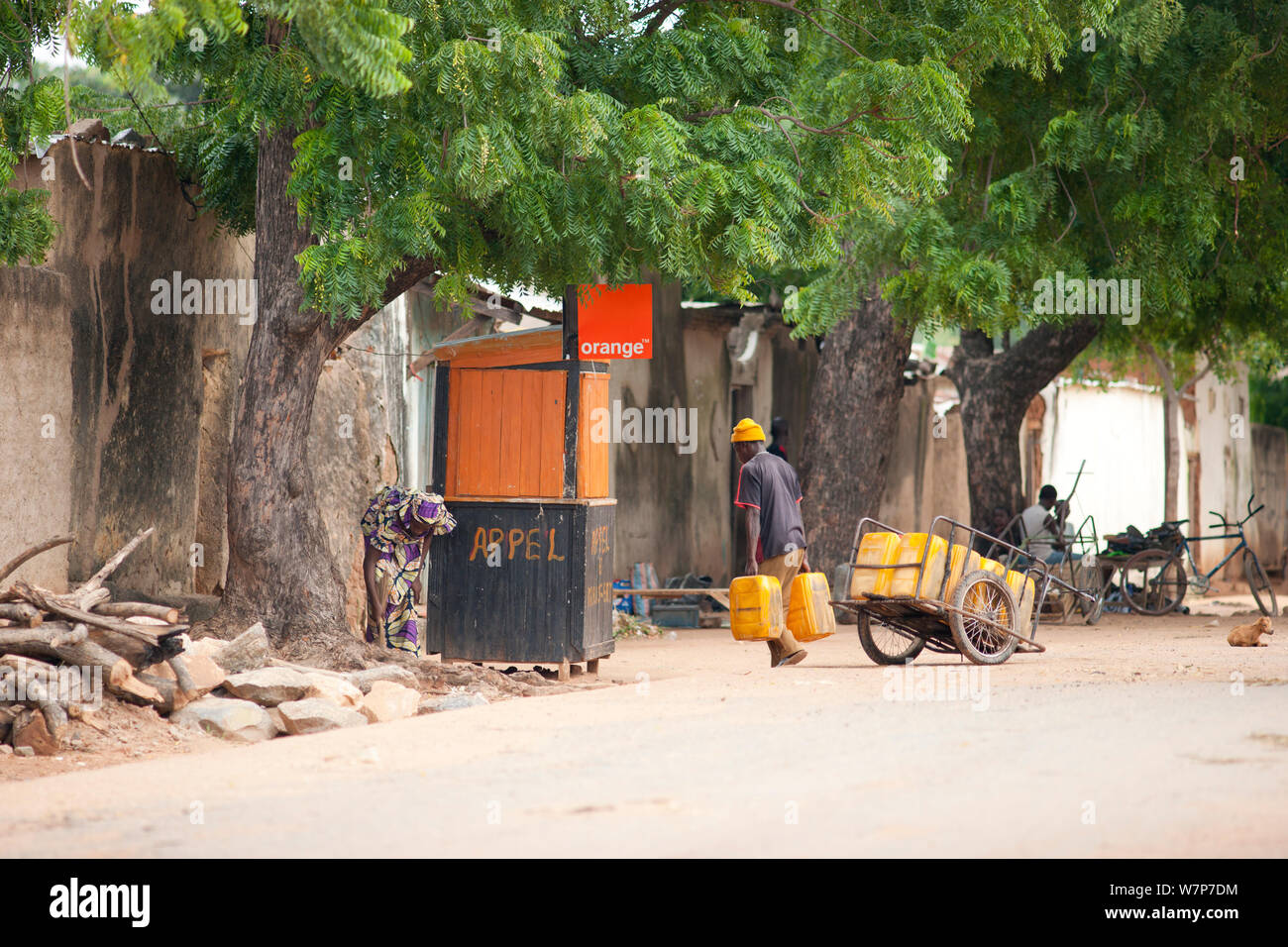 Scène de rue illustrant les bases telles que l'eau, du bois pour la cuisine, et des communications (téléphonie mobile) ont à être livrés indépendamment de la grille, le canton de Kousseri, le nord du Cameroun. 2009 Banque D'Images