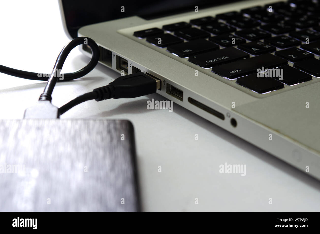 Disque dur externe pour connecter un ordinateur portable sur le fond blanc. Banque D'Images
