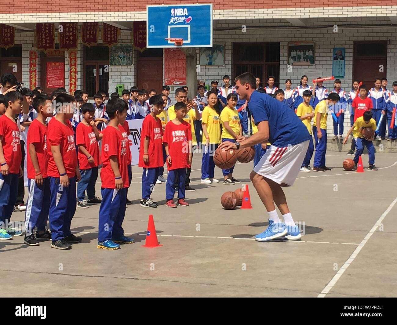 Joueur de basket-ball italien Danilo Gallinari donne aux élèves de jouer au basket-ball dans une école des enfants de travailleurs migrants dans la région de Guiyang city, au sud-ouest C Banque D'Images