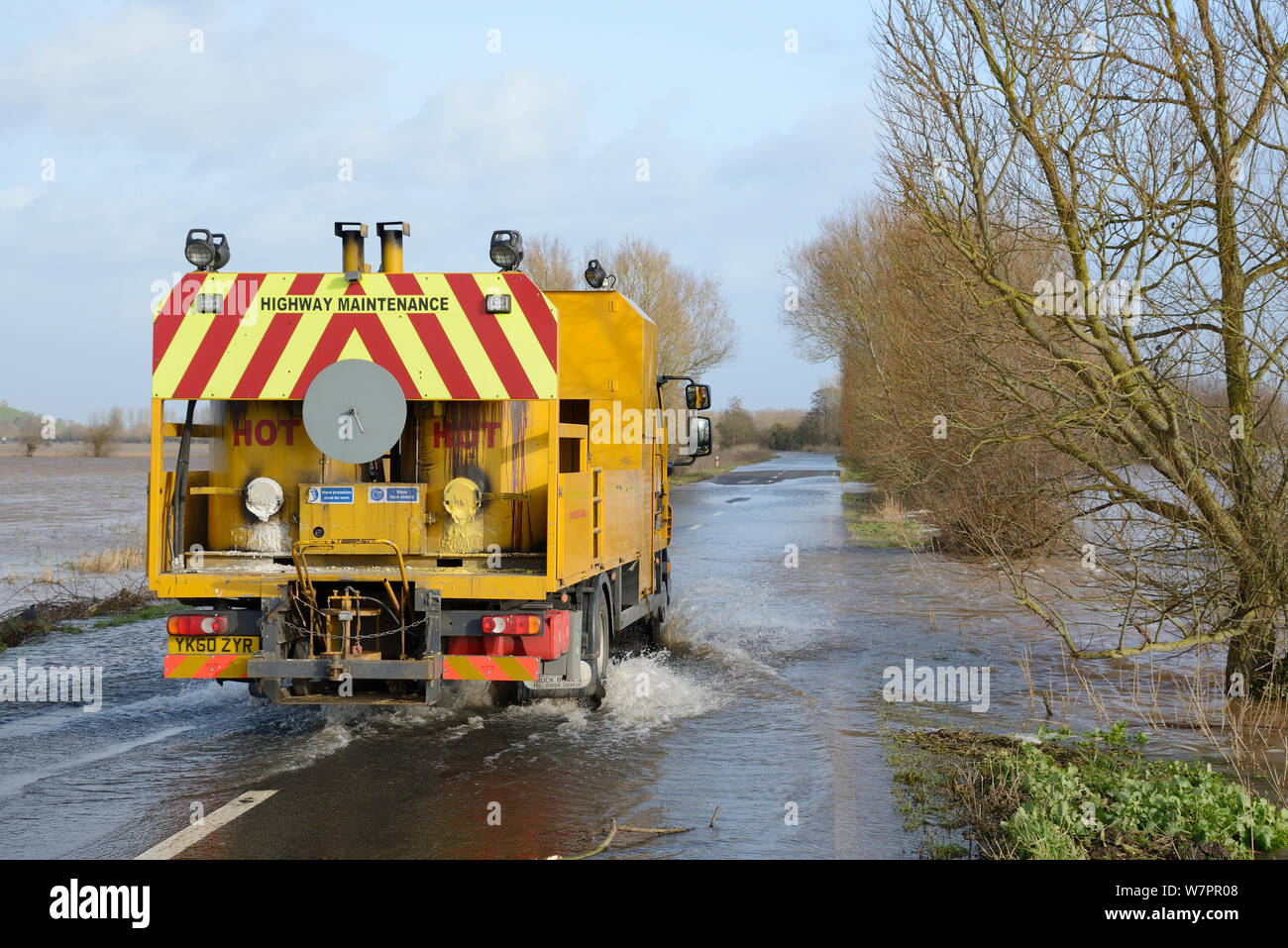 Véhicule d'entretien des routes en passant par les inondations sur gravement inondé A361 entre l'Est et l'ensemble Burrowbridge Lyng Sel inférieur Moor après des semaines de forte pluie, les niveaux de Somerset, au Royaume-Uni, en janvier 2013. Banque D'Images