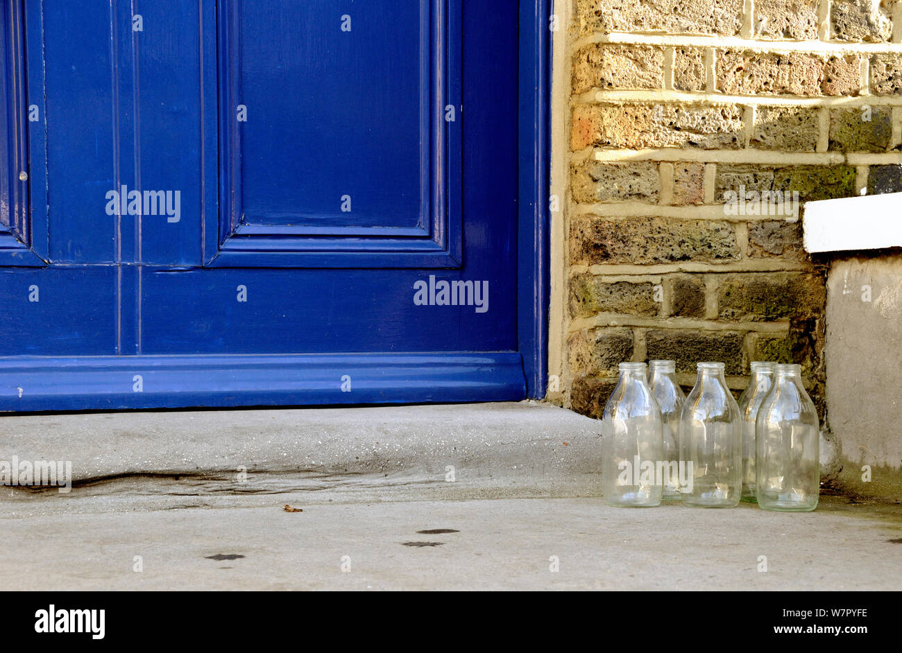 Cinq bouteilles de lait en verre vide sur le démarchage, London Borough of Islington, England, UK Banque D'Images