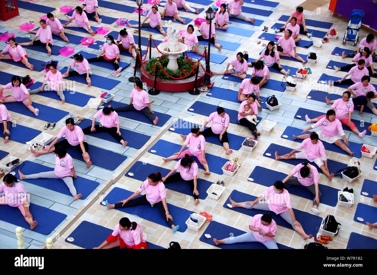 Les femmes enceintes yoga pratique sur une place dans la ville de Wuhan, province du Hubei en Chine centrale, 17 juin 2017. Des milliers de femmes enceintes yoga effectué et Banque D'Images