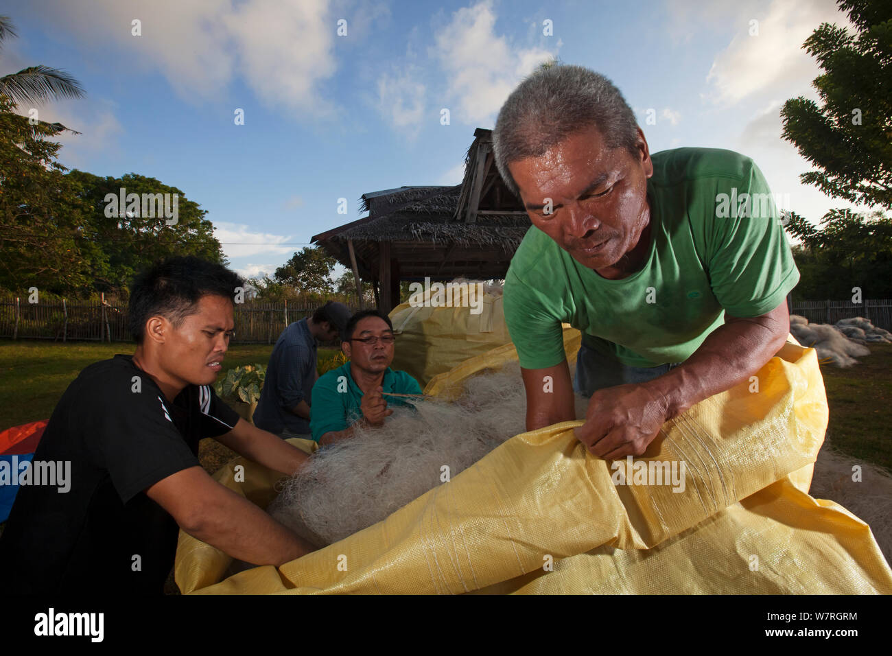 Le personnel de la fondation du Projet hippocampe avec deux tonnes de filets de pêche en plastique prêt à être expédié et recyclés en matière de tapis, Jao Island, banc Danajon, Central Visayas, Philippines, Avril 2013 Banque D'Images