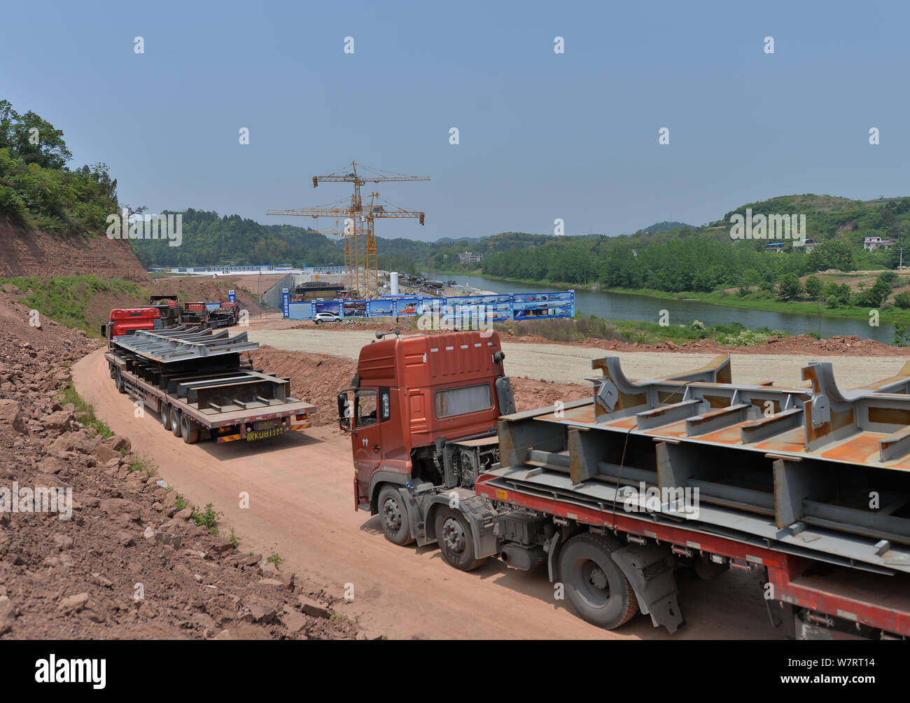 Transport camions matières premières jusqu'au site de construction d'une réplique grandeur nature du paquebot Titanic dans le comté de Daying, ville de Suining, southwe Banque D'Images
