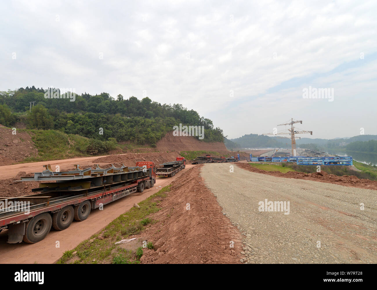 Transport camions matières premières jusqu'au site de construction d'une réplique grandeur nature du paquebot Titanic dans le comté de Daying, ville de Suining, southwe Banque D'Images