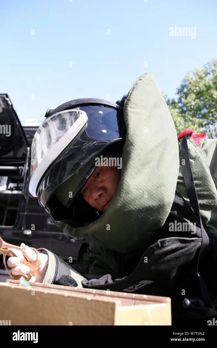 L'enlèvement des explosifs policier chinois Luo Jinfang portant un vêtement de protection qu'elle désarme les bombes à Zhenjiang city, Jiangsu province de Chine orientale, le 14 mai 2017 Banque D'Images
