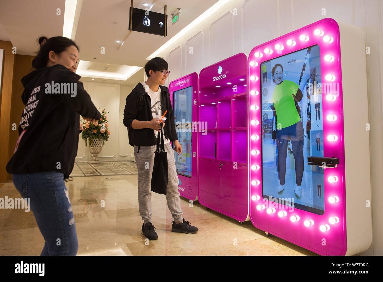 Une femme essaie sur les vêtements à l'aide d'un salon d'essayage virtuel 3D à un centre commercial à Nanjing, Jiangsu province de Chine orientale, le 8 mai 2017. Les consommateurs essayé o Banque D'Images