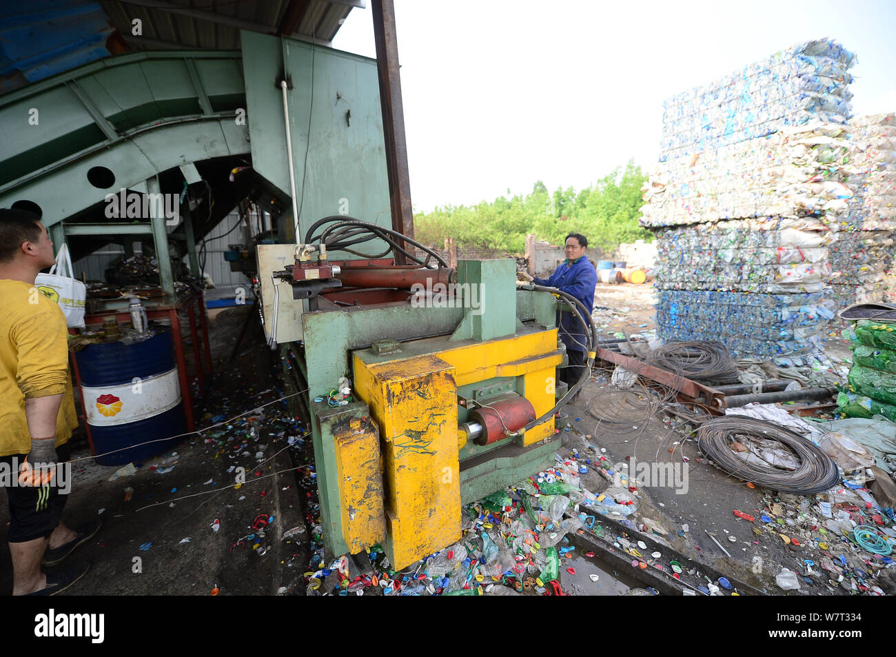 Les travailleurs chinois en plastique des bouteilles sur le processus de recyclage de plastique, qui piège un homme, dans la ville de Ji'nan, l'est la province de Shandong, Chine Banque D'Images
