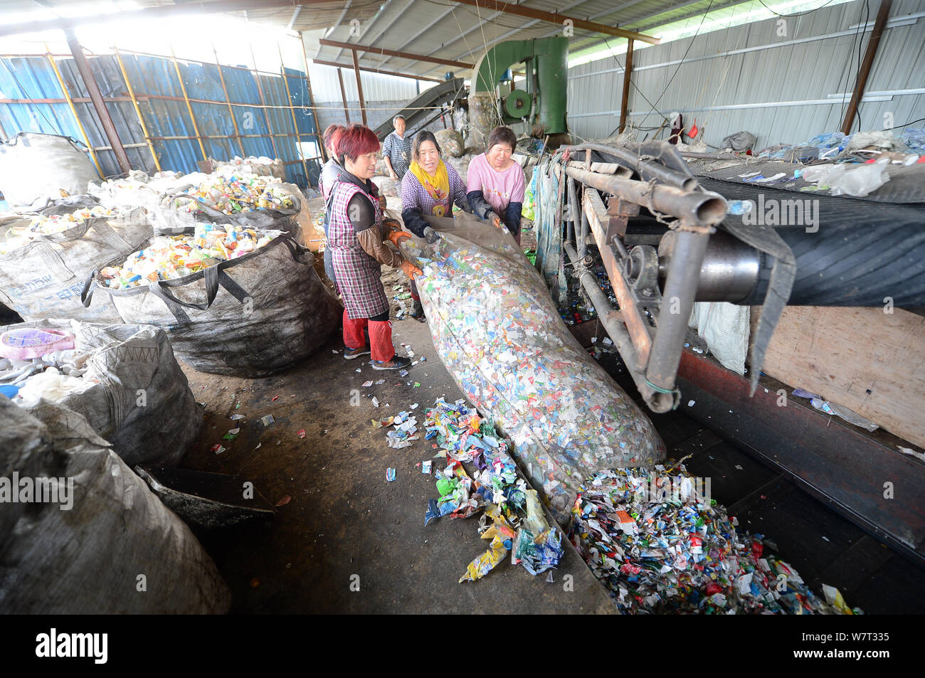 Les travailleurs chinois en plastique des bouteilles sur le processus de recyclage de plastique, qui piège un homme, dans la ville de Ji'nan, l'est la province de Shandong, Chine Banque D'Images