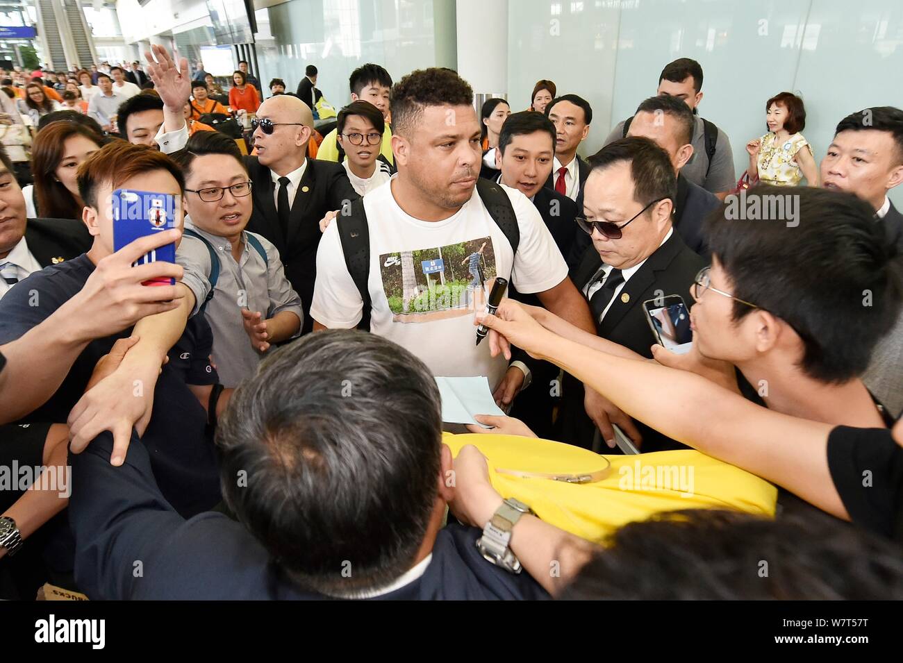 La star brésilienne du football Ronaldo Luis Nazario de Lima, centre, communément connu sous le nom de Ronaldo, est entouré de fans à l'Aéroport International de Hong Kong Banque D'Images