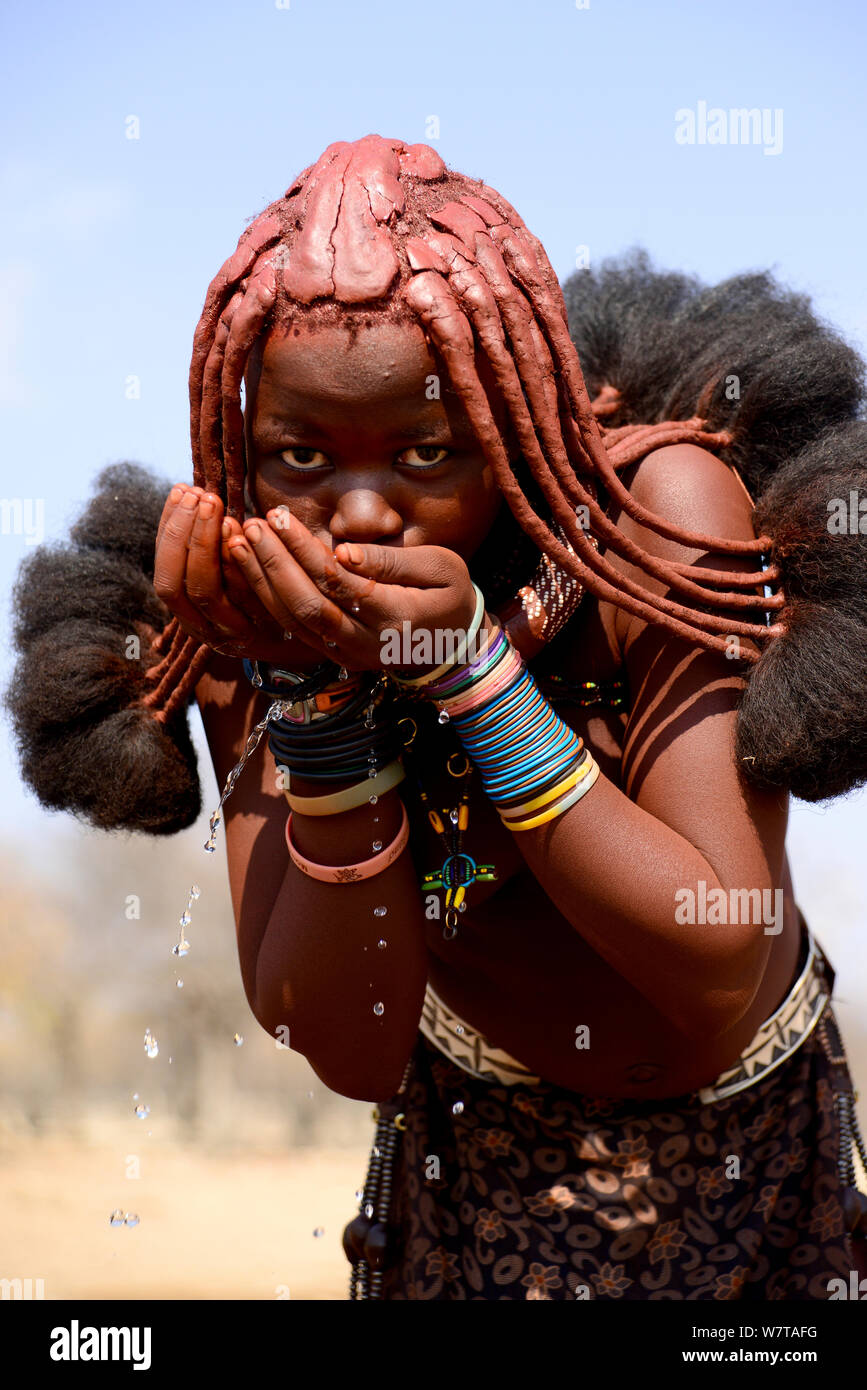 Jeune femme Himba buvant à une fontaine. Kaokoland, Namibie, septembre 2013. Banque D'Images