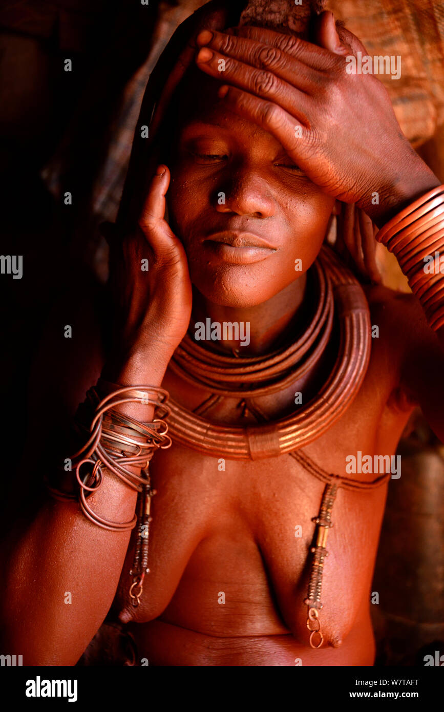 Femme Himba (Otjize appliquer un mélange de beurre, d'ocre et de cendres) à sa peau, Kaokoland, Namibie, septembre 2013. Banque D'Images