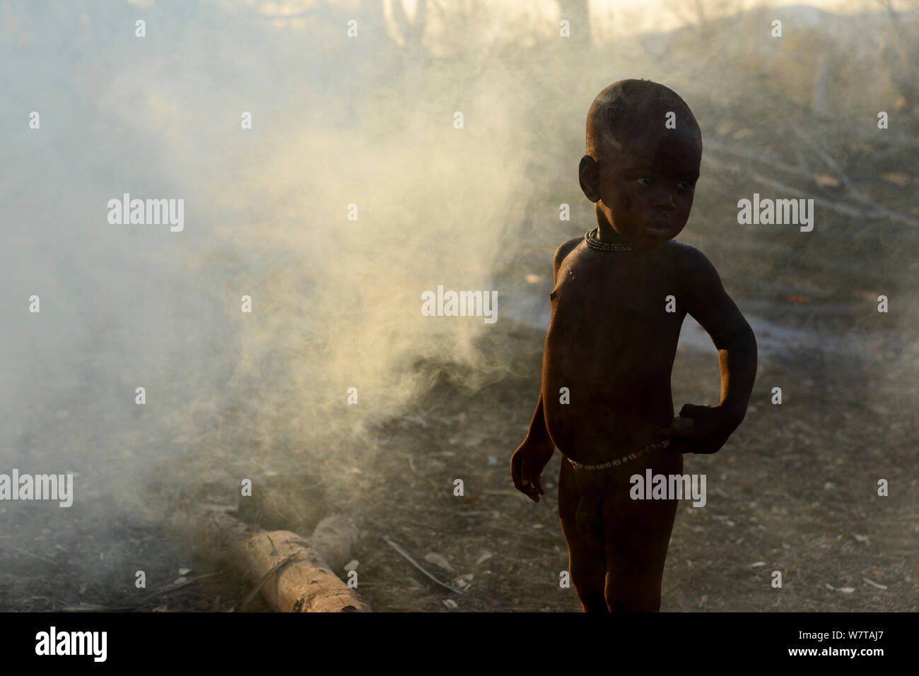 Enfant Himba dans la fumée d'incendie. Kaokoland, Namibie, septembre 2013. Banque D'Images