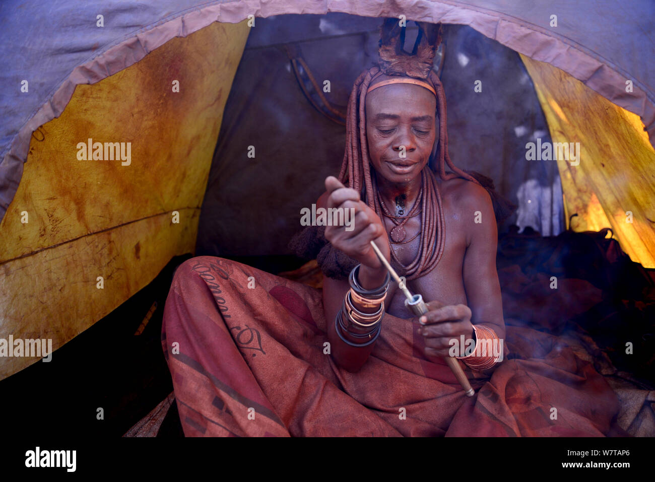 Femme Himba tabac à priser nasal renifler dans tente de camping, village Himba, Kaokoland, Namibie, septembre 2013. Banque D'Images