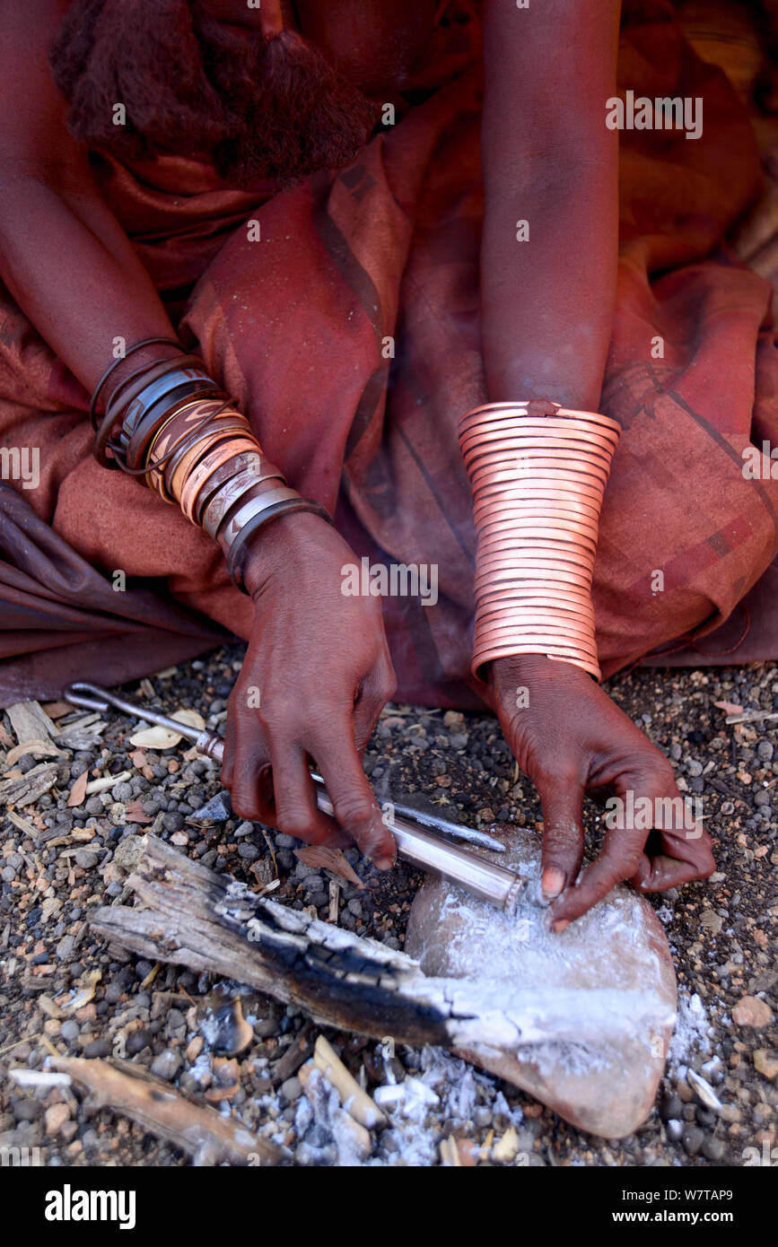 Femme Himba la préparation du tabac à priser nasal. Himba village, Kaokoland, Namibie, septembre 2013. Banque D'Images