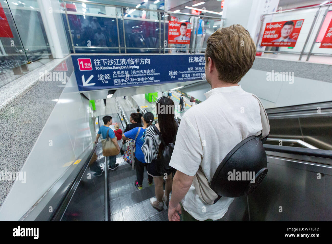 L'homme russe Dmitri, vêtu de vêtements traditionnels chinois et de transporter un pot fixé à son dos, prend un escalator dans un métro à Hangzhou cit Banque D'Images