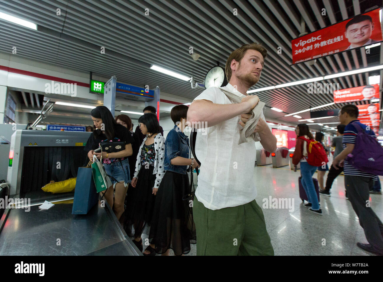 L'homme russe Dmitri, vêtu de vêtements traditionnels chinois, soutient un pot après un contrôle de sécurité à une station de métro dans la ville de Hangzhou, Zhejiang, Chine orientale Banque D'Images