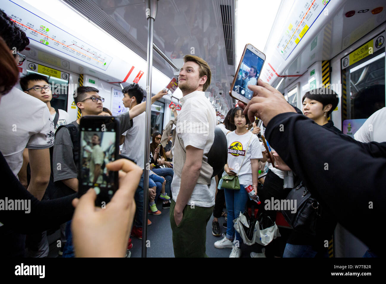 Les passagers de prendre des photos de l'homme russe Dmitri, vêtu de vêtements traditionnels chinois et de transporter un pot fixé à son retour, dans une rame de métro à Hangzh Banque D'Images