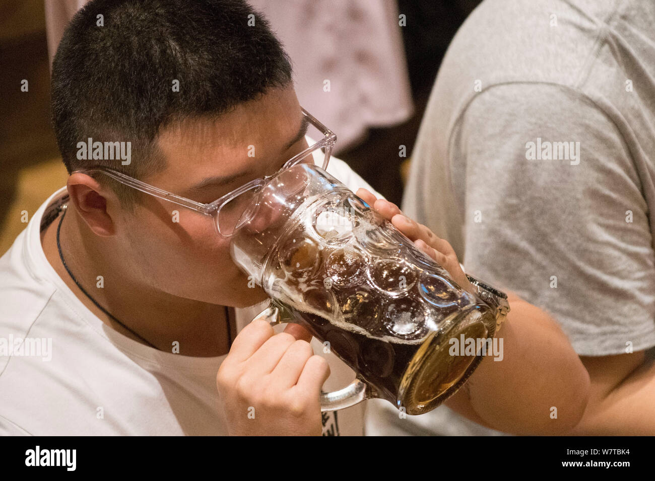 --FILE--Un homme Chinois obèses boit de la bière à un concours de l'alimentation, de l'est de la ville de Hangzhou dans la province du Zhejiang en Chine, 18 mai 2017. Trente pour cent de C Banque D'Images