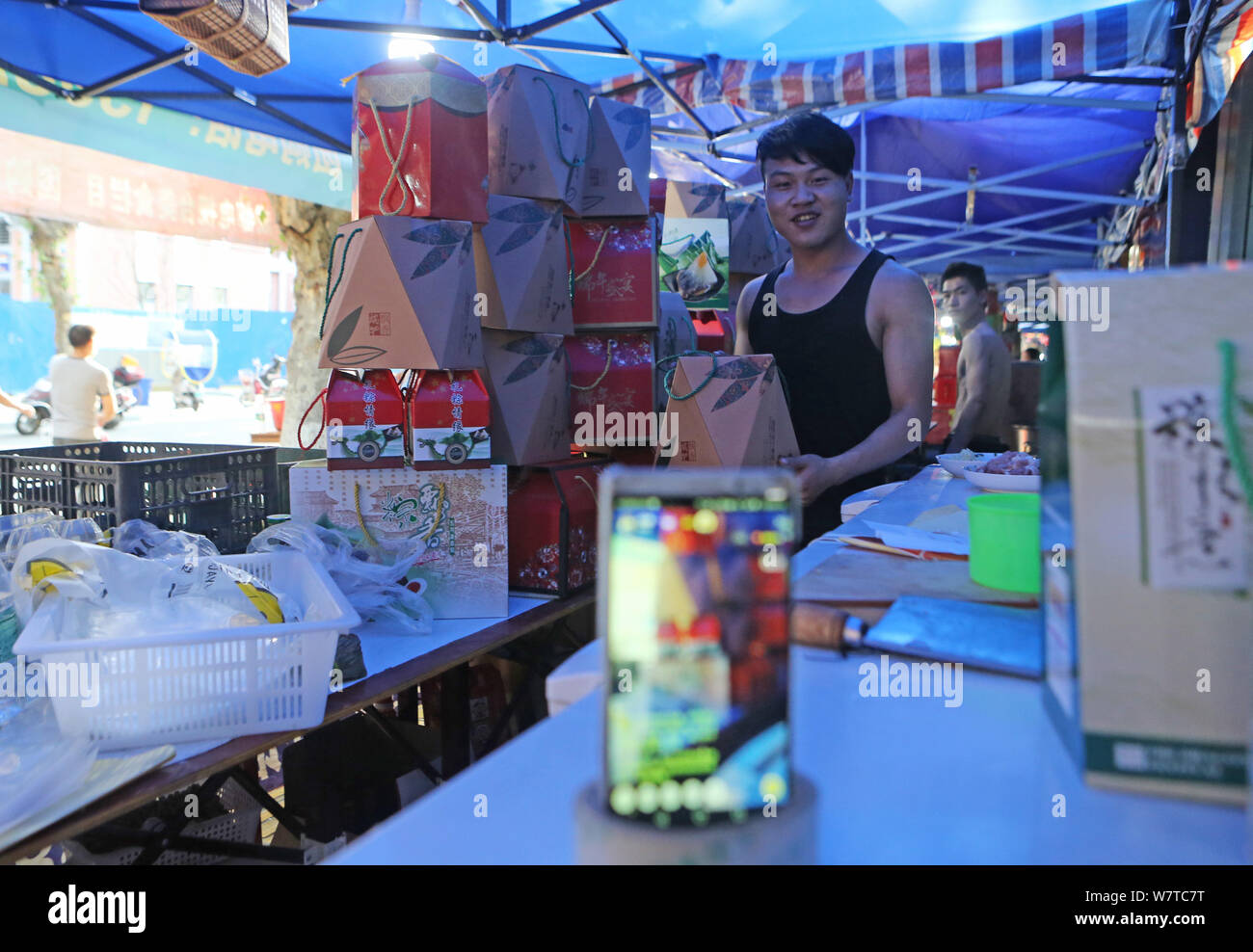 L'homme chinois Chen Rongfu propriétaire, qui a posté des vidéos sur les plateformes de streaming en direct pour montrer comment faire des boulettes de riz ou zongzi, travaille à son magasin, je zongzi Banque D'Images