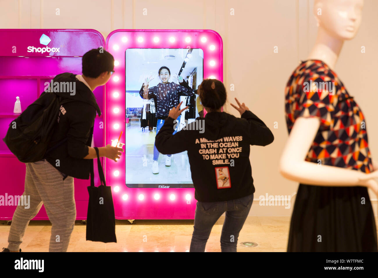 Une femme essaie sur les vêtements à l'aide d'un salon d'essayage virtuel 3D à un centre commercial à Nanjing, Jiangsu province de Chine orientale, le 8 mai 2017. Les consommateurs essayé o Banque D'Images