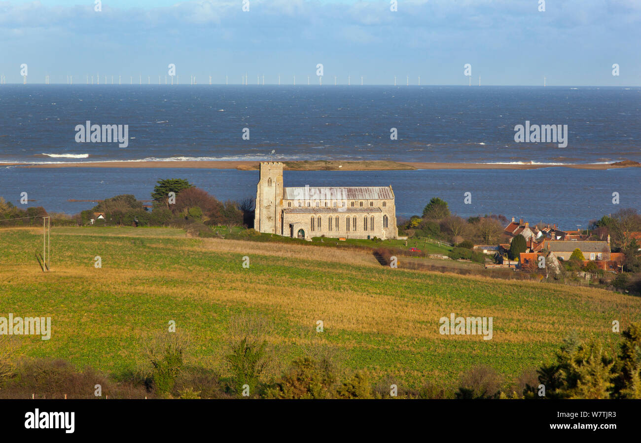 Vue vers l'église St Nicholas, avec pâturage inondé marsh et manqué de défense côtière de galets après le 6 décembre côte est raz-de-marée dans l'arrière-plan, Salthouse, Norfolk, England, UK, décembre 2013. Banque D'Images