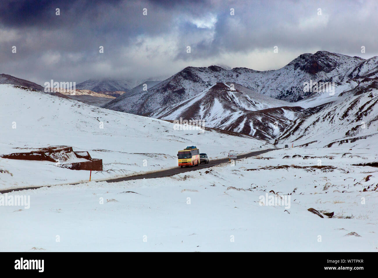 Bus et voiture sur le passage à niveau de la route des montagnes de l'Atlas à la fin de la neige, Maroc, Afrique du Nord, mars 2011. Banque D'Images