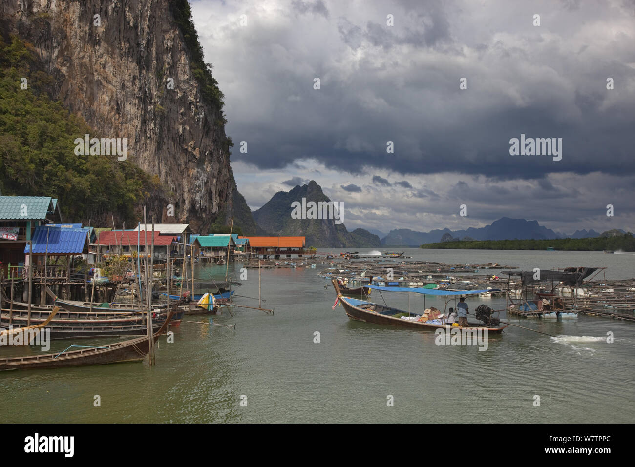 Des maisons sur pilotis et des bateaux dans les eaux côtières, Ko Panyi Village, province de Phang Nga, Thaïlande, décembre 2011. Banque D'Images