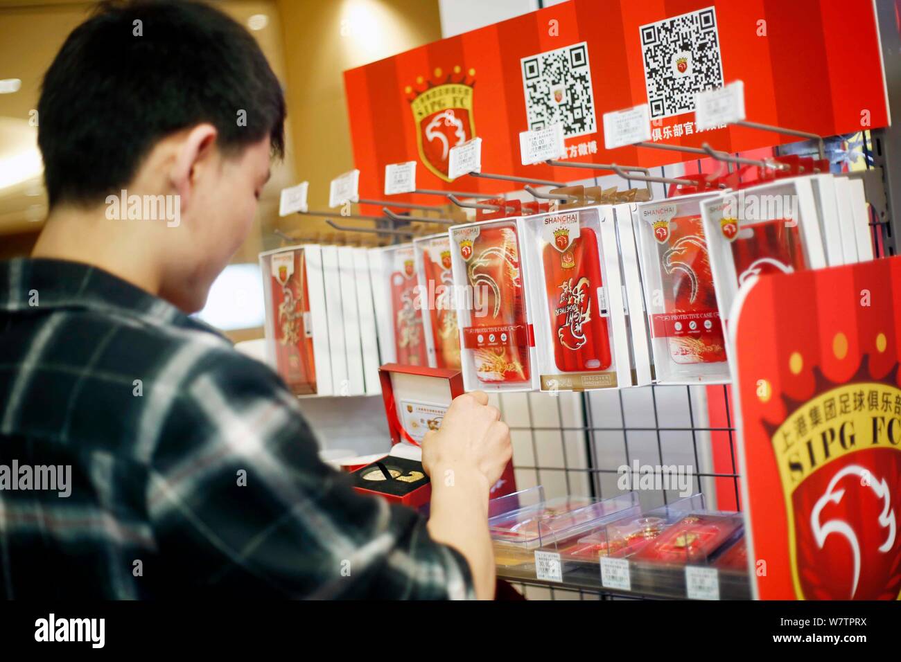 Un client chinois choisissez souvenirs de Shanghai EPOP au Lawson's nouveau concept store a coopéré avec Shanghai EPOP FC au Shanghai World Financial Banque D'Images
