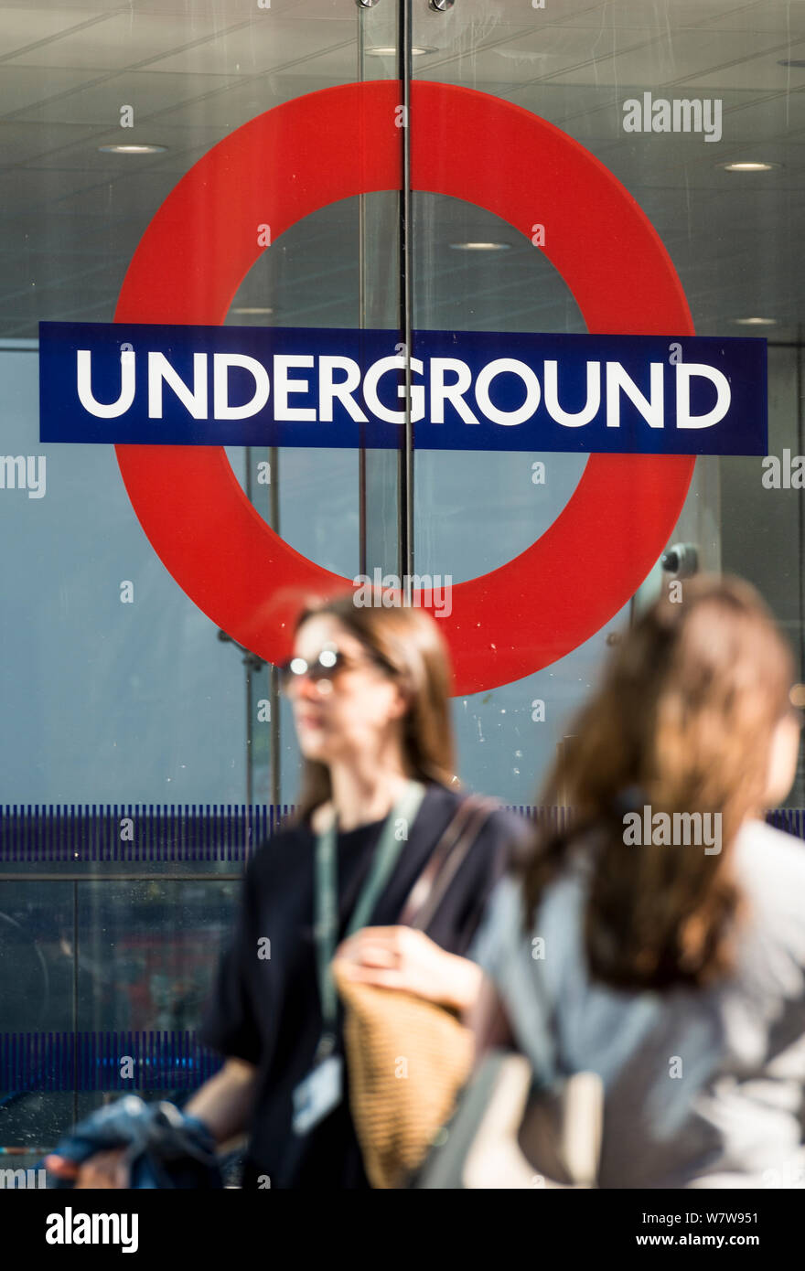 Deux femmes sur leur trajet du matin à l'entrée de la station de métro Victoria, au centre de Londres. Banque D'Images