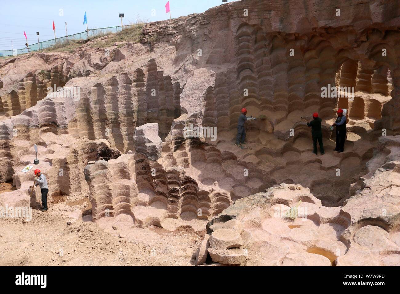 Les travailleurs chinois fouillent les 600 ans fosses meule étalées dans un 7 000 mètres carrés de zone pour obtenir des meules à moudre le riz et les haricots Banque D'Images