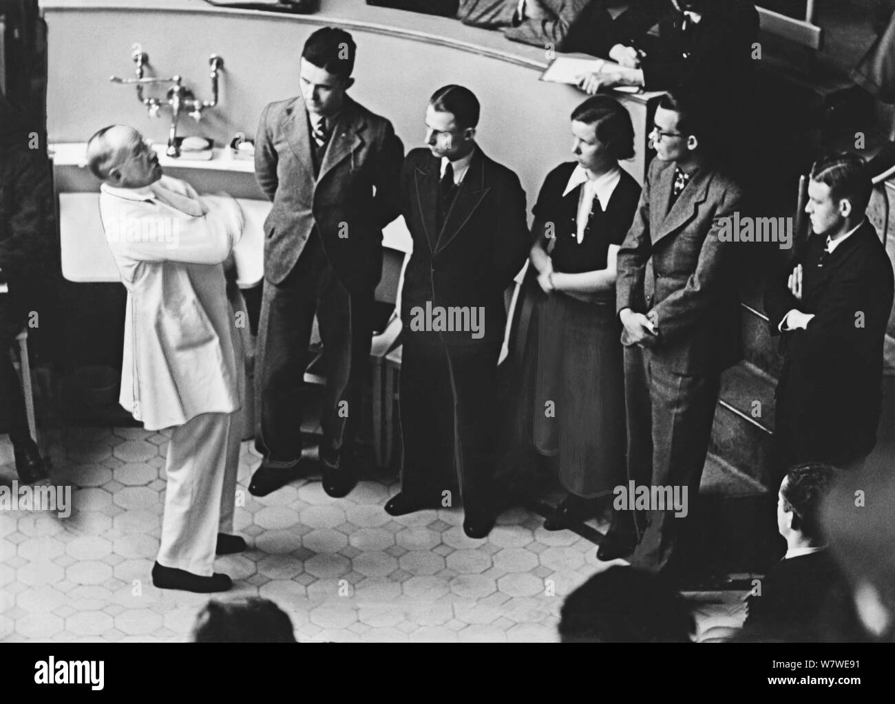 Le professeur Ferdinand Sauerbruch unterhält sich im Medizinstudenten mit der - la charité" à Berlin, Deutschland ca. 1935. Chirurgien Allemand Ferdinand Sauerbruch parlant à ses étudiants à l'auditorum de Charité à Berlin, Allemagne, ca. 1935. Banque D'Images