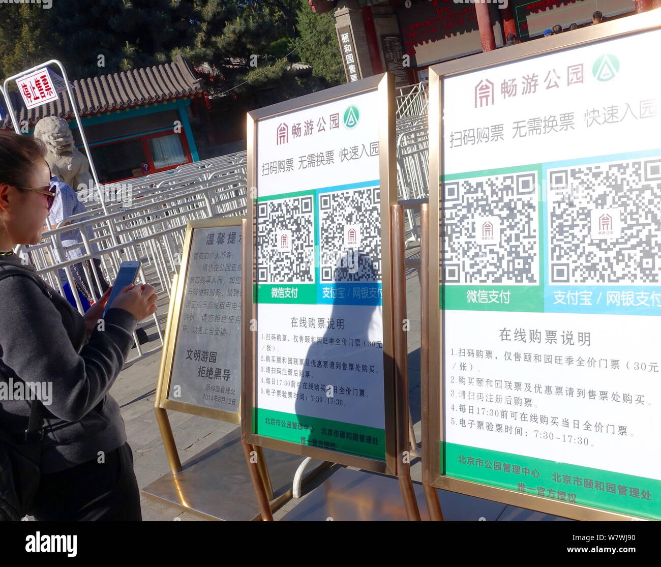 Un touriste utilise son smartphone pour scanner le code QR pour obtenir un e-ticket à l'extérieur d'un parc à Pékin, Chine, 27 avril 2017. Les touristes n'ont pas besoin de faire la queue Banque D'Images