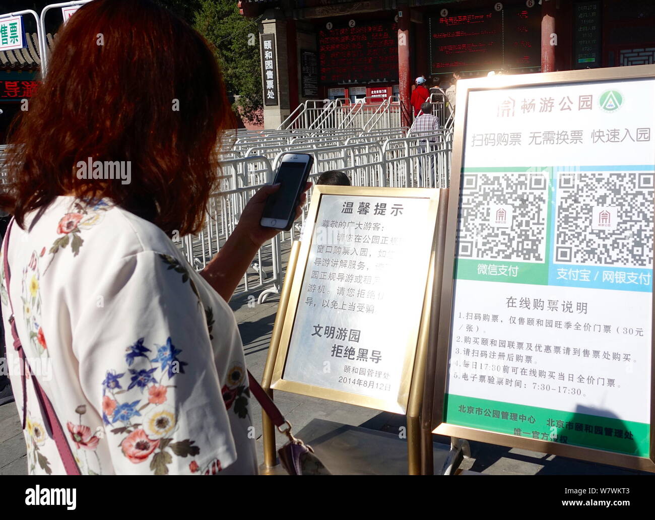 Un touriste utilise son smartphone pour scanner le code QR pour obtenir un e-ticket à l'extérieur d'un parc à Pékin, Chine, 27 avril 2017. Les touristes n'ont pas besoin de faire la queue Banque D'Images