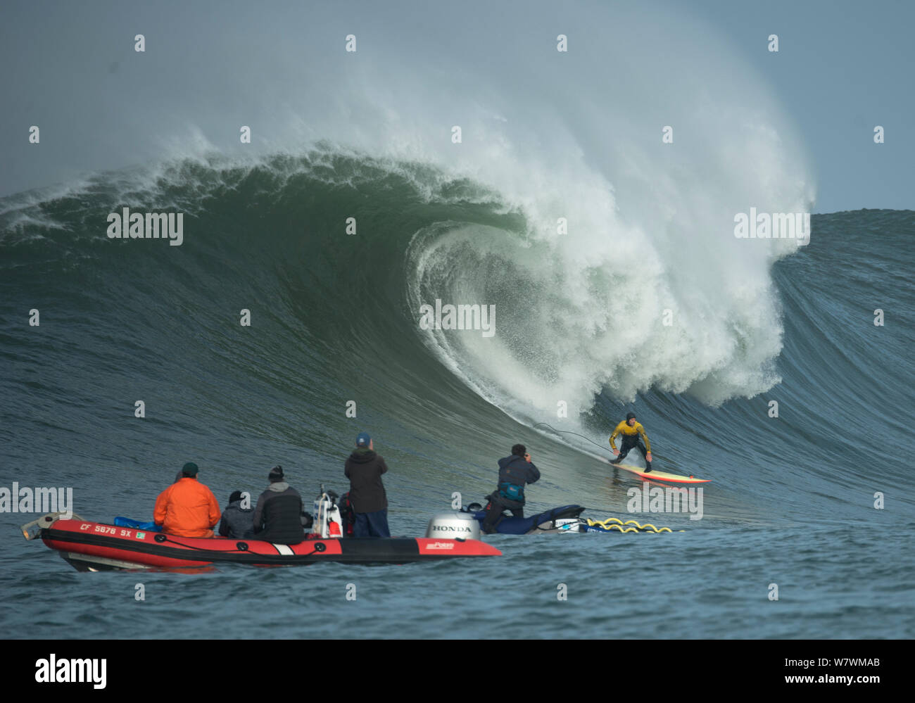 Surfer en compétition dans les Mavericks 2014 Concours surf, regardés par les personnes sur la nervure, Half Moon Bay, Californie, USA, janvier 2014. Banque D'Images