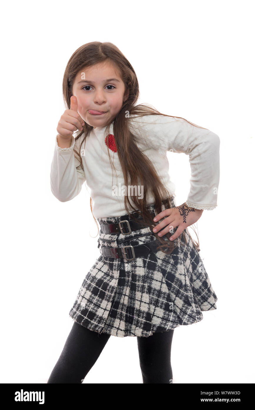 Jeune fille avec la langue dehors et Thumbs Up, drôle Expression Teasing Banque D'Images