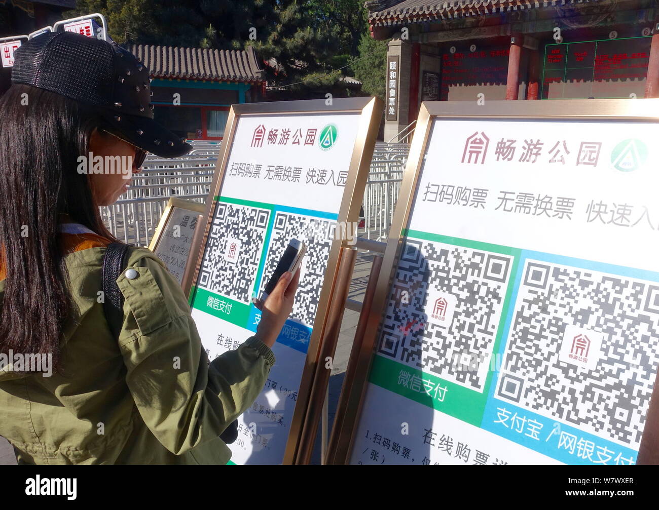 Un touriste utilise son smartphone pour scanner le code QR pour obtenir un e-ticket à l'extérieur d'un parc à Pékin, Chine, 27 avril 2017. Les touristes n'ont pas besoin de faire la queue Banque D'Images