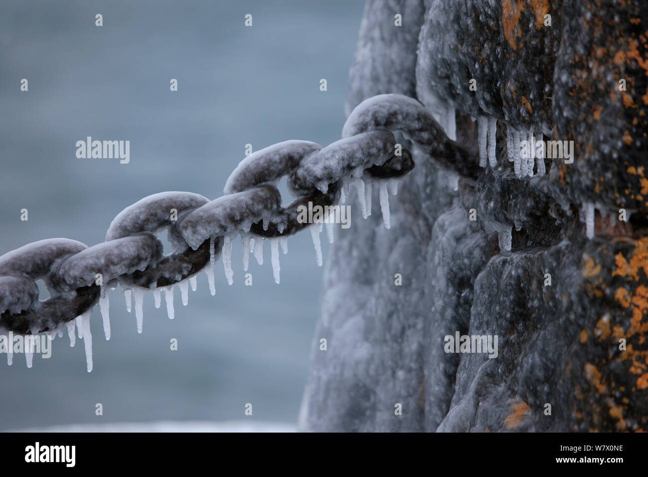 Couvrant de glace vieille chaîne rouillée et pierre barrière, lac Supérieur, Gooseberry Falls State Park, Minnesota, décembre. Banque D'Images