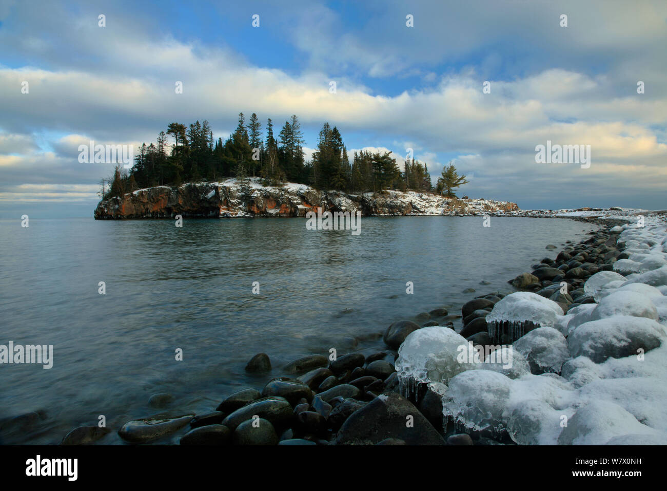 Des roches couvertes de glace sur les rives du lac Supérieur, vue de l'Île Ellingson. Le phare de Split Rock State Park, Minnesota, décembre 2011. Banque D'Images