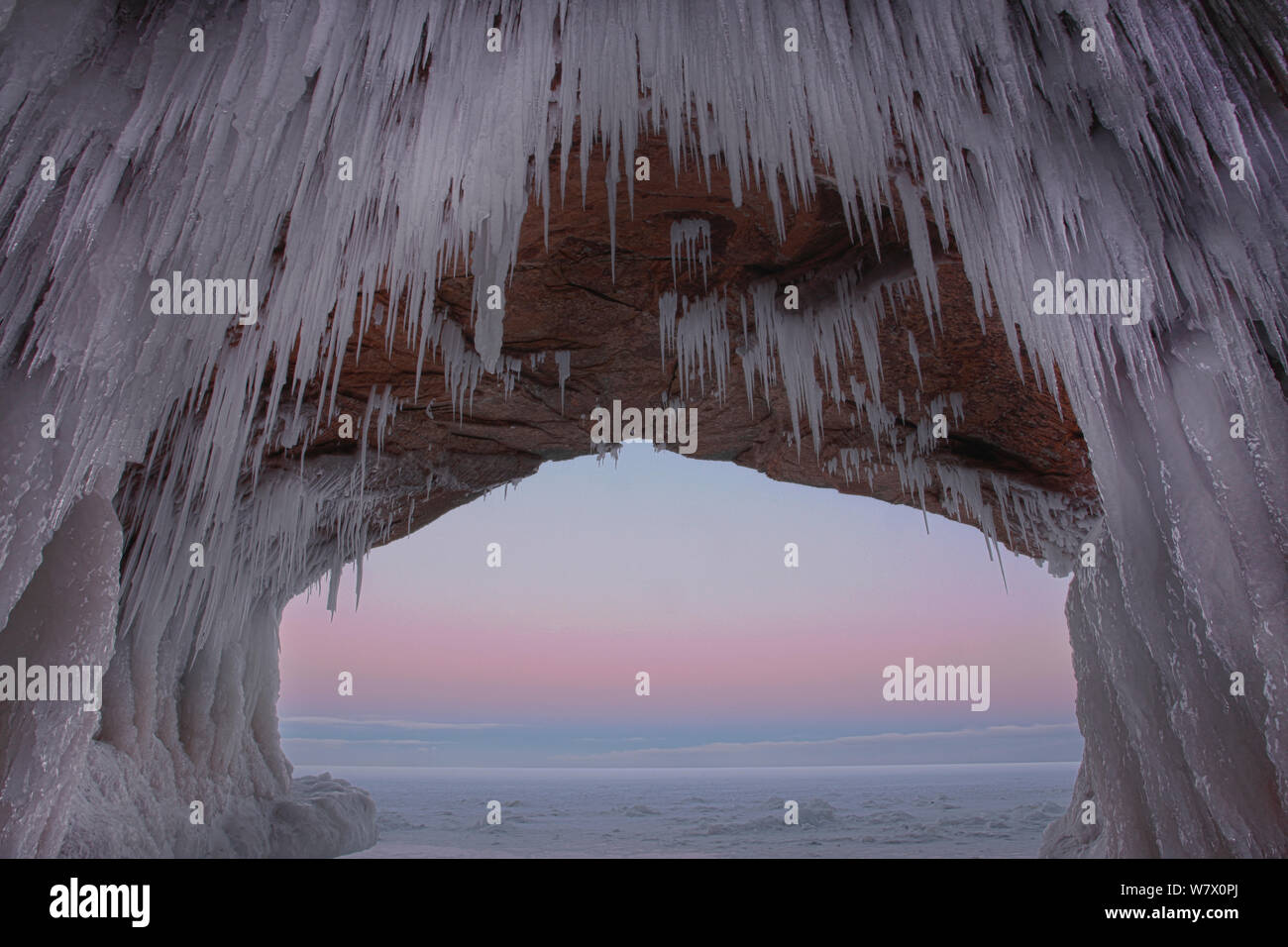 Glaçons pendant de archway grès dans grotte marine à l'aube. Îles Apostle National Lakeshore, lac Supérieur, Squaw Bay (Wisconsin), février 2014. L'exposition de 3 images composites. Banque D'Images