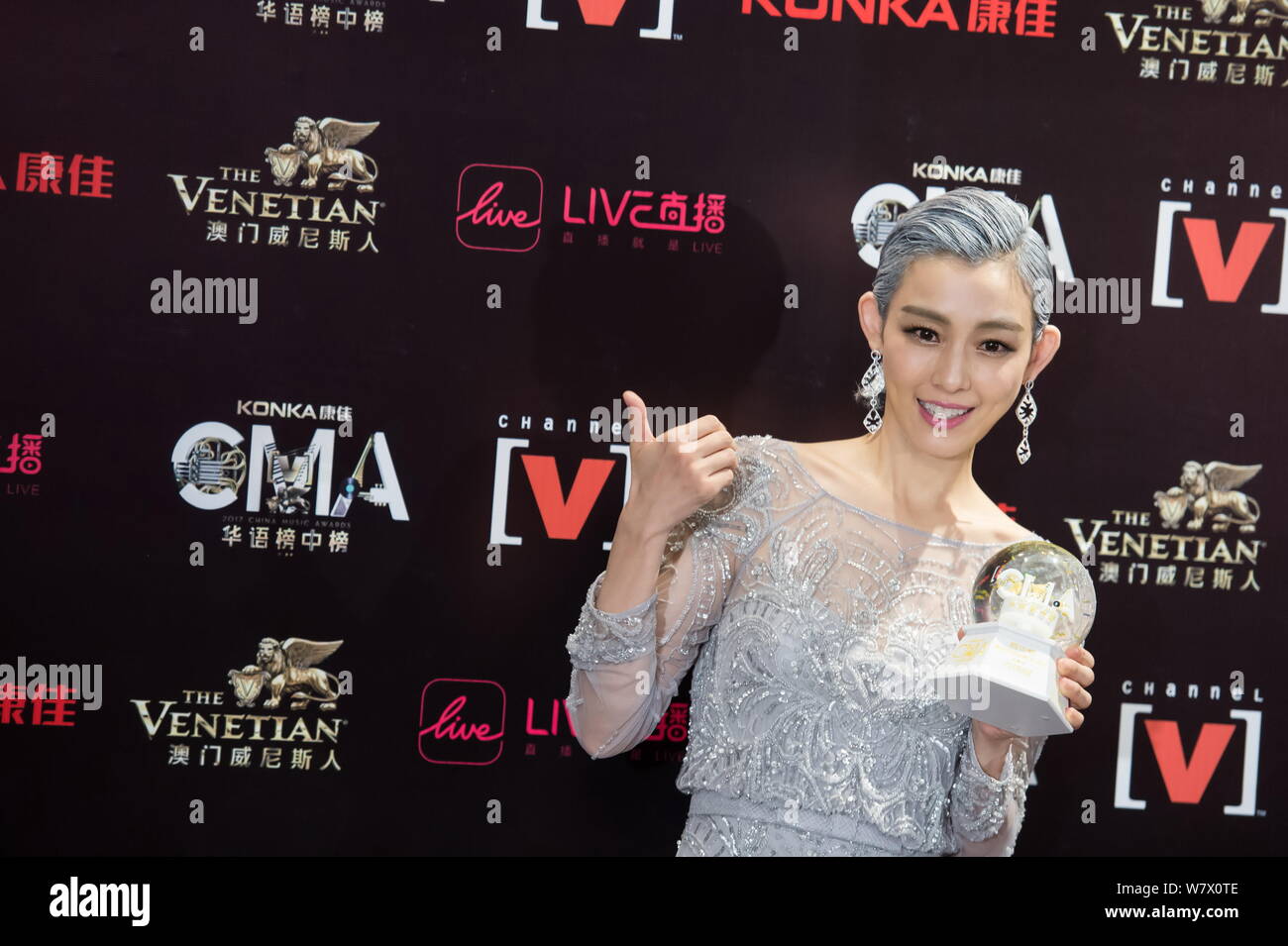Chanteuse et actrice taïwanaise Christine pose fièrement avec son ventilateur au cours de la Chine 21 trophées Music Awards à Macao, Chine, 20 avril 2017. Banque D'Images
