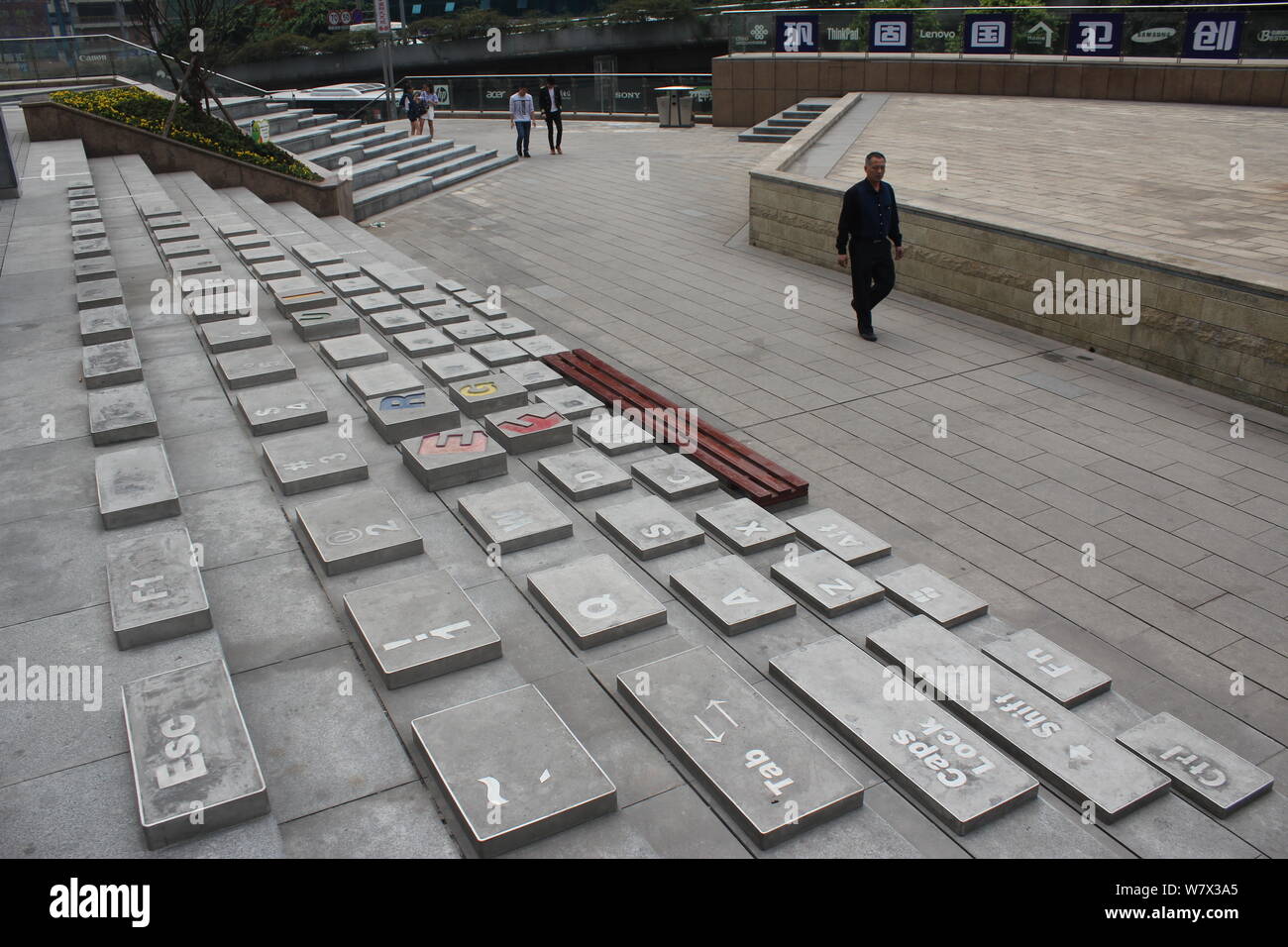 Un piéton marche dernières plaques de pierres peintes dans les escaliers avec une forme d'un clavier d'ordinateur à proximité d'un centre commercial à thème-il à Chongqing, Chine, Banque D'Images