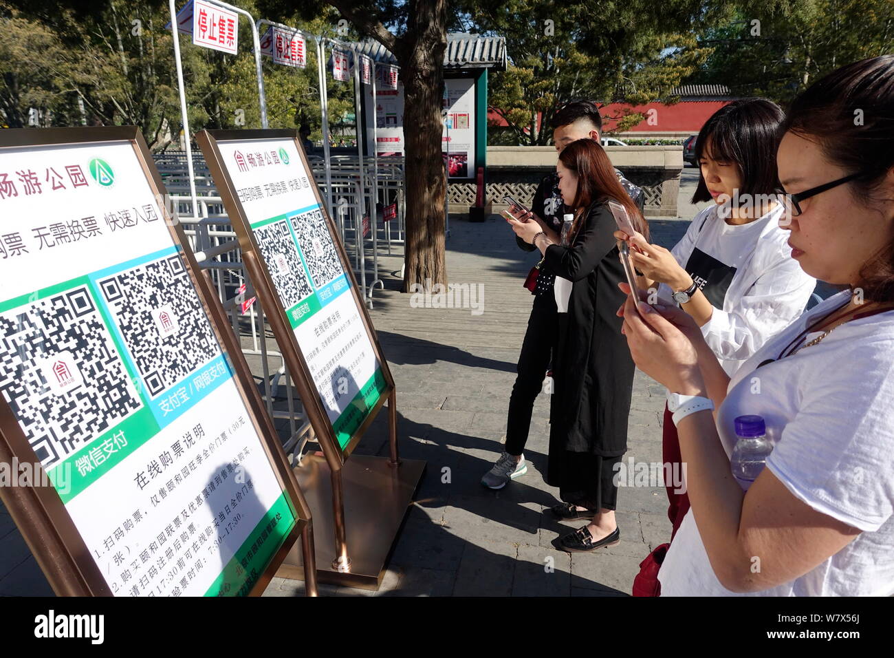Touristes utilisent leur smartphone pour scanner le code QR pour télécharger vos billets à l'extérieur d'un parc à Pékin, Chine, 27 avril 2017. Les touristes n'ont pas besoin d'attente d'u Banque D'Images