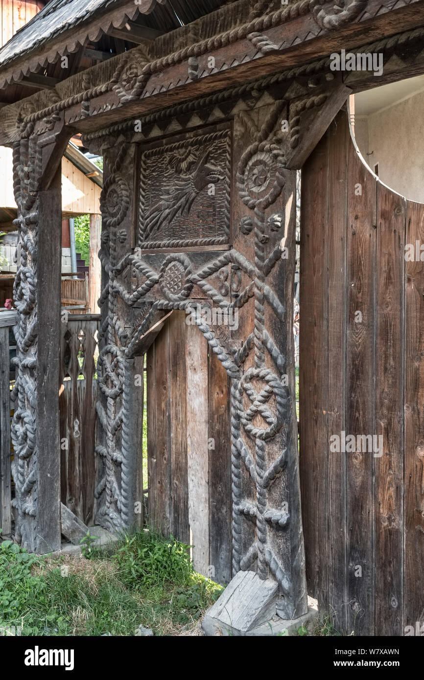 Botiza, Maramureș, Roumanie. Portes en bois sculptés à l'extérieur de maisons de village sont une caractéristique de la région Banque D'Images