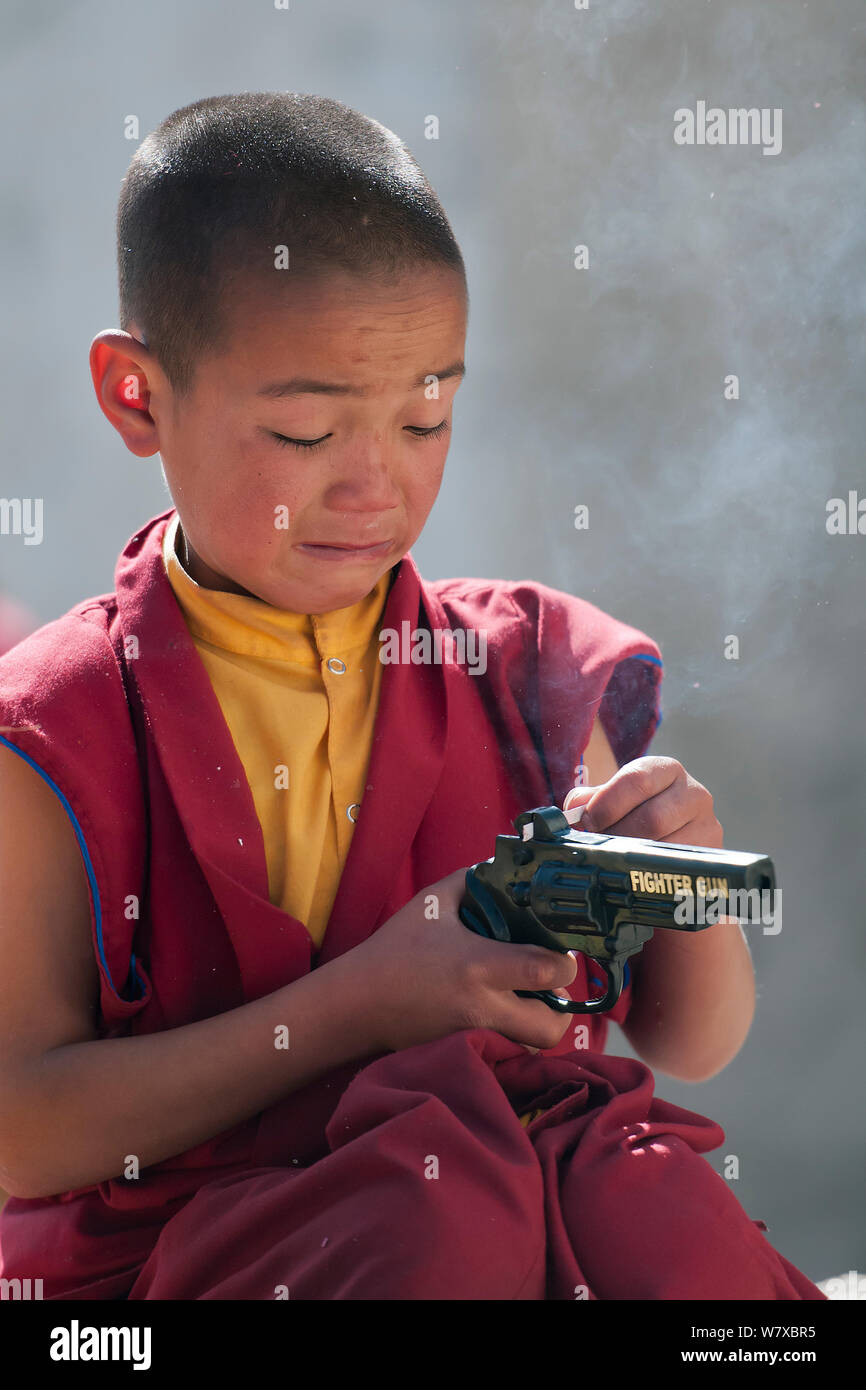 Jeune moine à Torgya festival avec pistolet jouet en plastique. Galdan Lhatse Namge,Monastère Tawang, de l'Arunachal Pradesh, Inde. Janvier 2014. Banque D'Images